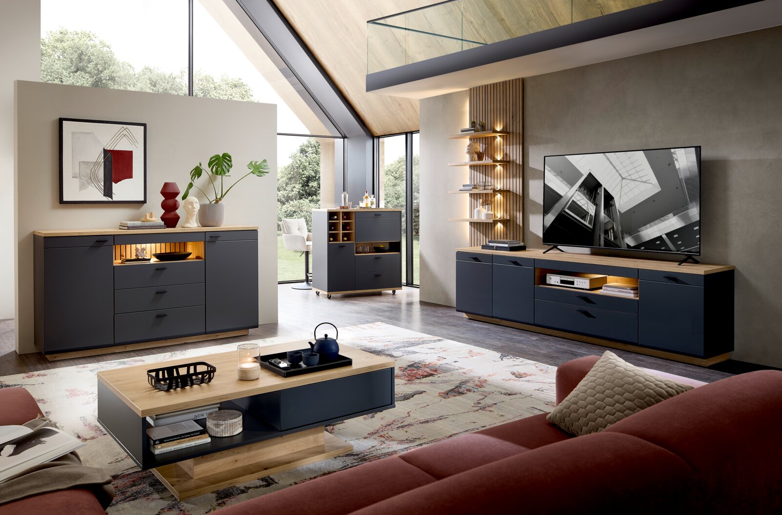 Stylife Raumteiler-Kombi-Element RENO Moderner Wohnraum mit stilvollen, dunkelgrauen Möbeln, darunter ein Raumteiler-Kombi-Element, aus der Perspektive eines gemütlichen Wohnzimmers mit großen Fenstern und viel Tageslicht.
