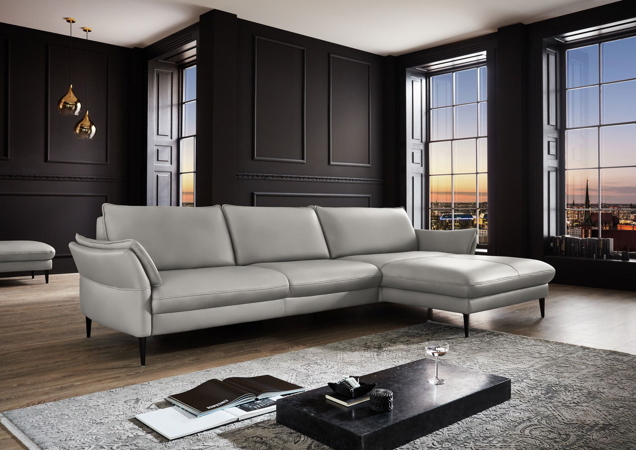 Elegante Longchairkombination in einem modernen Wohnzimmer mit großen Fenstern und stilvoller Dekoration, seitliche Perspektive.