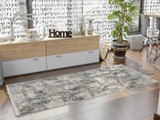 Moderner Designer Teppich in einem hellen Raum mit Holzboden, dekoriert mit Pflanzen und Büchern, aus der Vogelperspektive betrachtet.