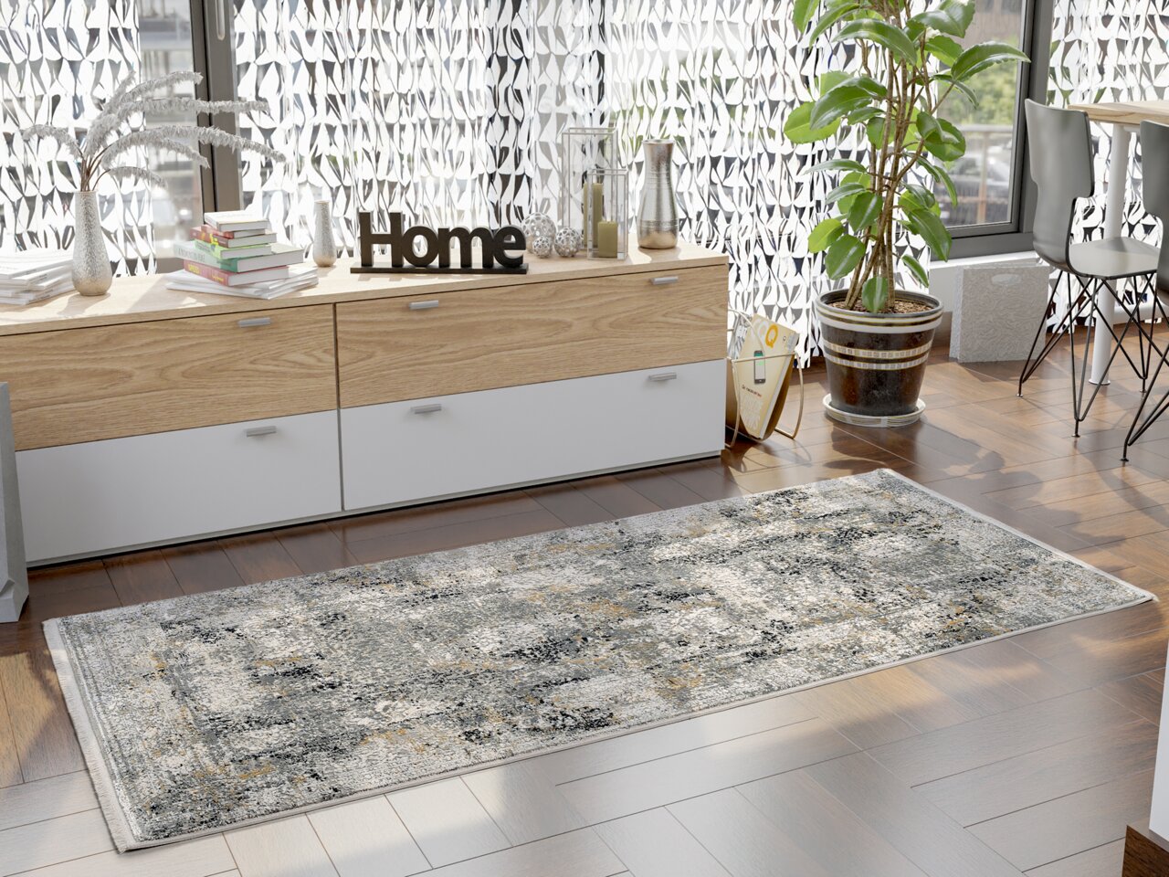 Moderner Designer Teppich in einem hellen Raum mit Holzboden, dekoriert mit Pflanzen und Büchern, aus der Vogelperspektive betrachtet.