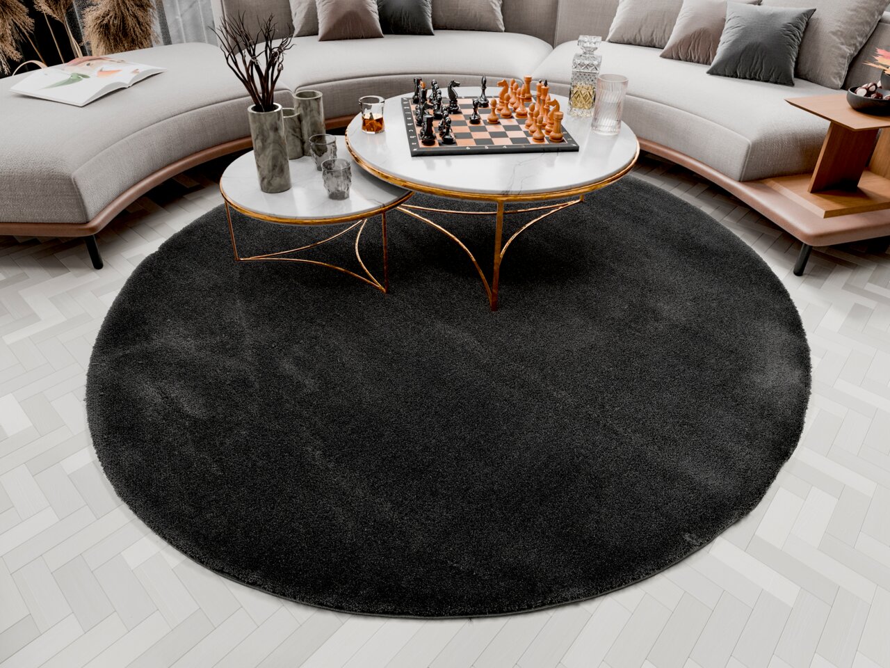 Runder, dunkelgrauer Hochflor-Teppich in einem modernen Wohnzimmer, von oben betrachtet. Der Teppich liegt unter einem runden Couchtisch mit Marmorplatte und goldenen Beinen, umgeben von einem geschwungenen Sofa.