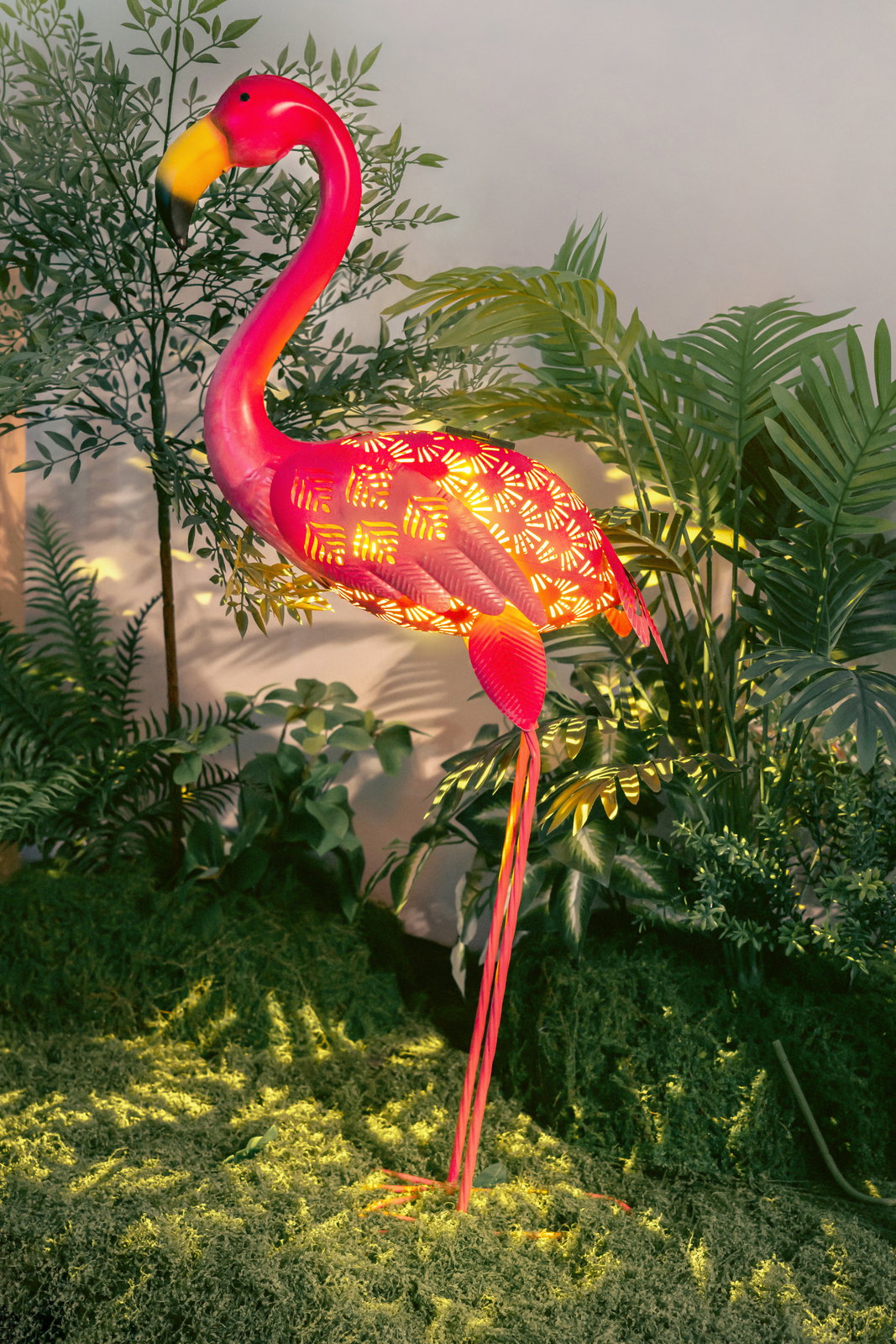 Solarbetriebene Flamingo-Gartenleuchte in tropischer Umgebung, seitliche Perspektive