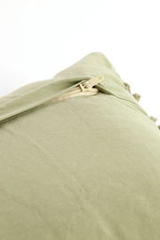 Nahaufnahme eines grünen Kissens mit Reißverschluss, perspektivisch von oben fotografiert.