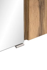 Nahaufnahme eines Spiegelschranks mit Holzrahmen und Metallgriff, seitliche Perspektive