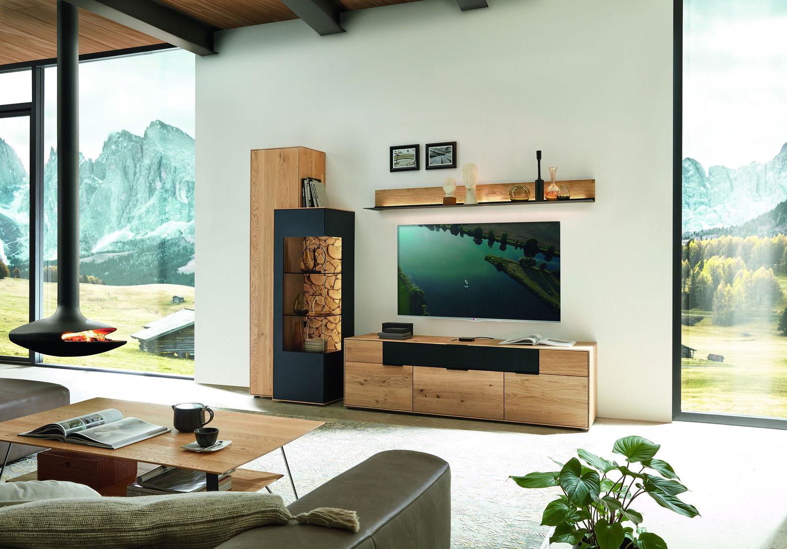 Modernes Wohnzimmer mit Wandbord, das Holzscheite und Dekorationen präsentiert, im Hintergrund eine malerische Berglandschaft. Perspektive: Frontalansicht.