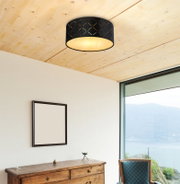 Moderne Deckenleuchte mit schwarzem, geometrischem Muster, von unten betrachtet, in einem stilvollen Raum mit Holzelementen und Panoramafenster.