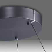 Nahaufnahme der Unterseite einer modernen, runden Pendelleuchte in mattem Schwarz mit zwei Kabeln, die von der Decke hängen.