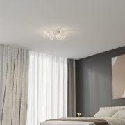 Moderne witte led-plafondlamp met gebogen lichtstralen aan het plafond, warme verlichting in de slaapkamer, licht van onderaf gezien
