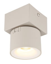 Weiße, schwenkbare LED-Deckenleuchte mit quadratischem Baldachin und zylindrischem Spot, warm leuchtend, in Nahaufnahme aus leicht schräger Untersicht