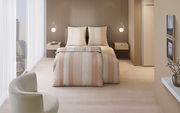 Modernes Schlafzimmer mit eleganter Bettwäsche in Beige- und Cremetönen, Streifenmuster, von vorne betrachtet.
