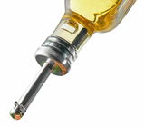 Nahaufnahme eines Ausgießers, der in eine Flasche eingesetzt ist, mit einer metallischen Spitze und einer klaren Flüssigkeit im Hintergrund.