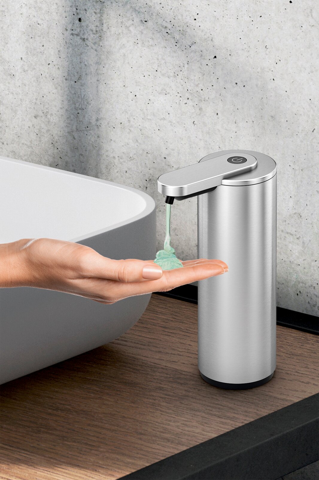 ZACK Sensor-Seifenspender TERVO Edelstahl-Seifenspender mit Sensor gibt grünes Flüssigseifen-Gel in eine ausgestreckte Hand neben einem Waschbecken ab, seitliche Nahaufnahme aus leicht erhöhter Perspektive