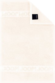 Cremefarbenes JOOP! Frottierhandtuch mit eingewebtem Logo-Bordürenstreifen und schwarzem Markenlabel, flach von oben fotografiert (Draufsicht)
