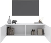 Wit hangend tv-meubel met twee open deuren, versierd met boeken, vazen en cadeaus, gezien vanaf de voorkant.