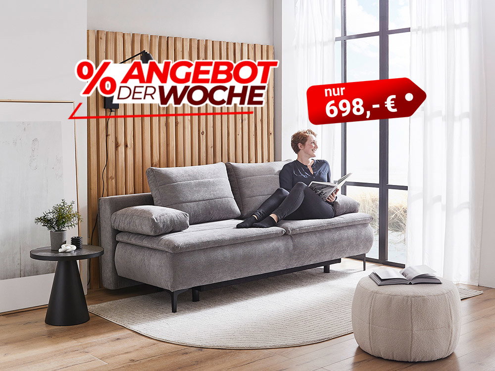 Frau liest auf grauem Sofa im modernen Wohnzimmer, Angebot der Woche Sofa für 698 €