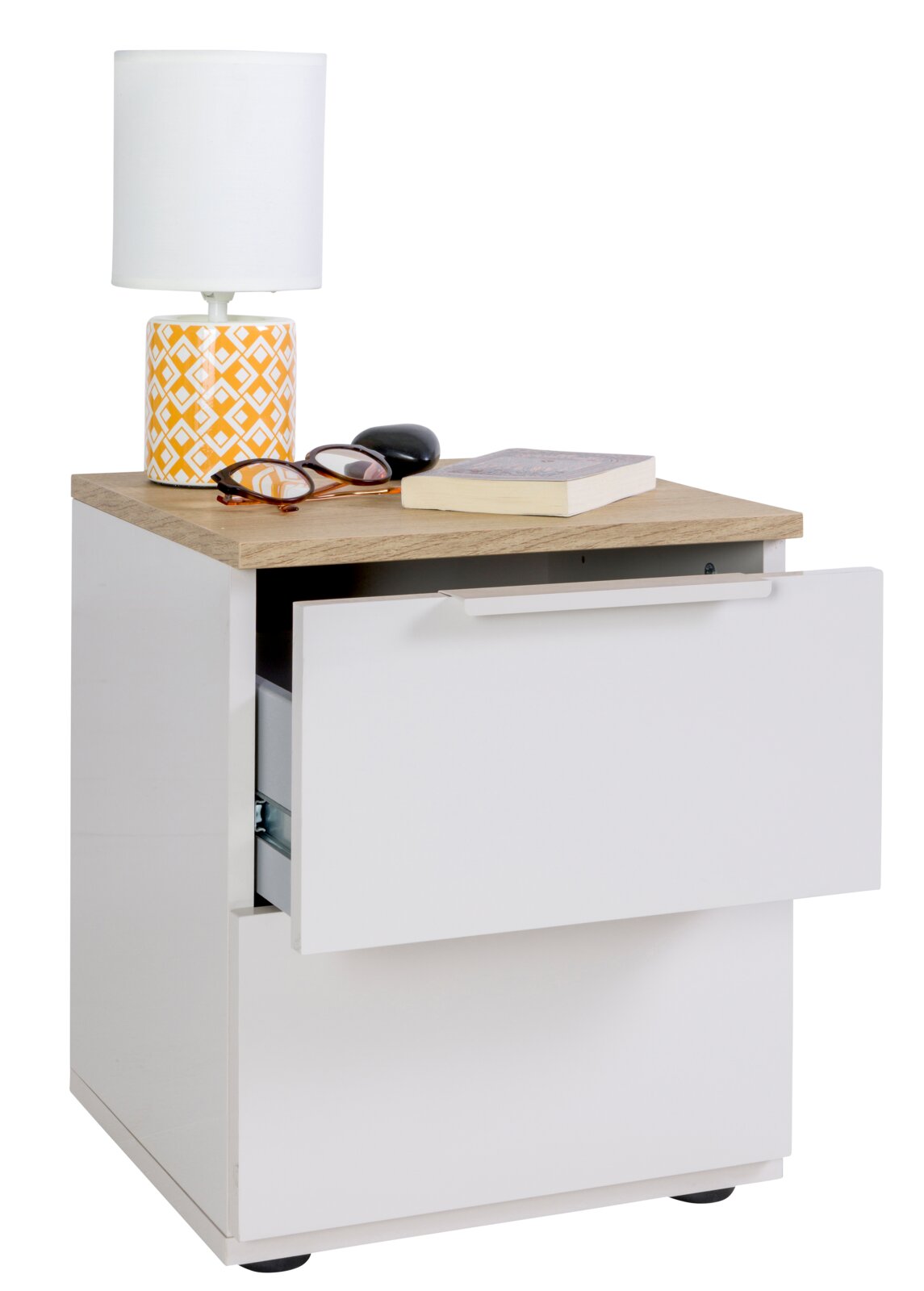 Weißer Nachttisch mit Holzoptik-Oberplatte und zwei Schubladen, obere Schublade halb geöffnet; darauf Tischlampe, Brille, Etui und Buch, Ansicht leicht von vorne links