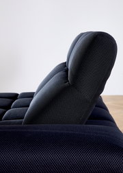 Seitenansicht einer modernen, dunkel gepolsterten Eckgarnitur mit strukturierter Oberfläche.