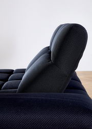 Seitenansicht einer modernen, dunkel gepolsterten Eckgarnitur mit strukturierter Oberfläche.