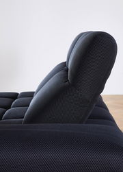 Seitenansicht einer modernen, dunkel gepolsterten Eckgarnitur mit strukturierter Oberfläche.