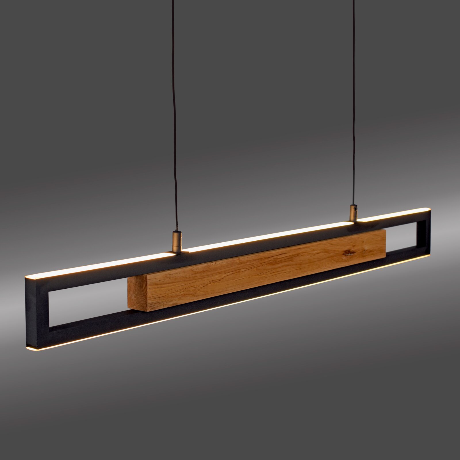 Moderne langwerpige hanglamp met warmwitte ledverlichting, zwart metalen frame en houten balk, schuin van voren en licht van onderen bekeken