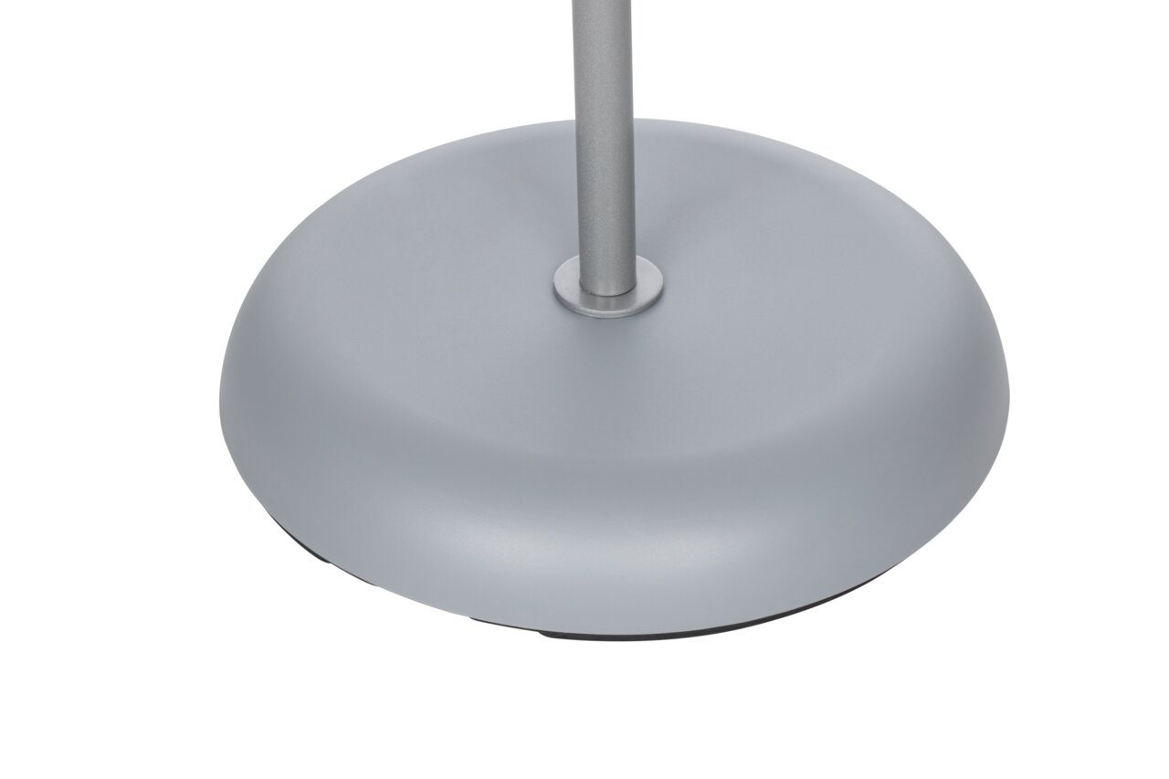 Close-up van de voet van een zilveren staande lamp, gezien vanuit vogelperspectief