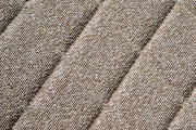 Nahaufnahme eines beige strukturierten Stoffes in diagonaler Perspektive.