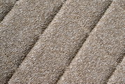 Nahaufnahme eines beige strukturierten Stoffes in diagonaler Perspektive.