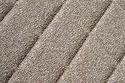 Nahaufnahme eines beige strukturierten Stoffes in diagonaler Perspektive.