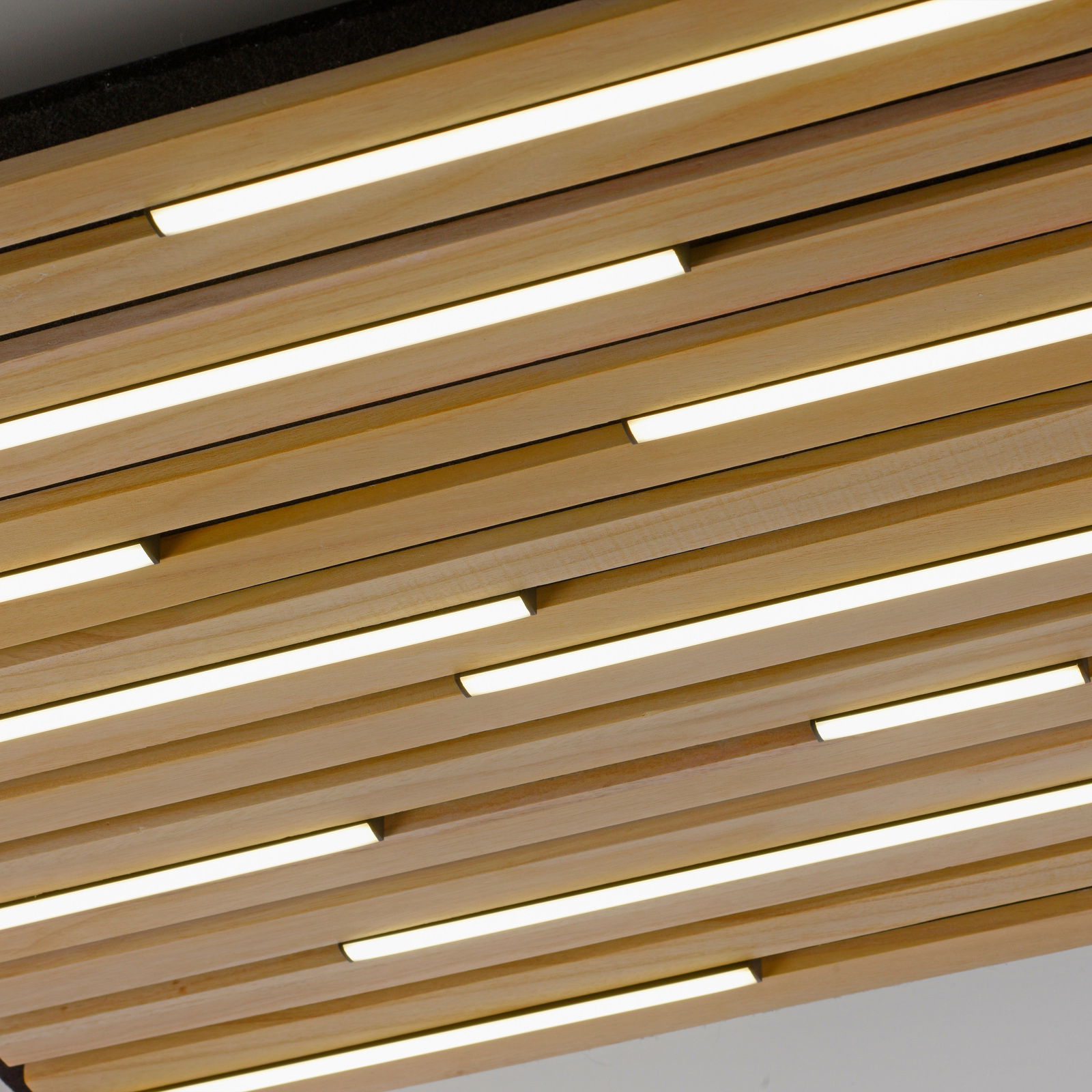 Moderne Wand- und Deckenleuchte Q-AKUS aus Holzlamellen mit integrierter LED-Beleuchtung, Perspektive von unten.