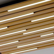 Moderne Wand- und Deckenleuchte Q-AKUS aus Holzlamellen mit integrierter LED-Beleuchtung, Perspektive von unten.