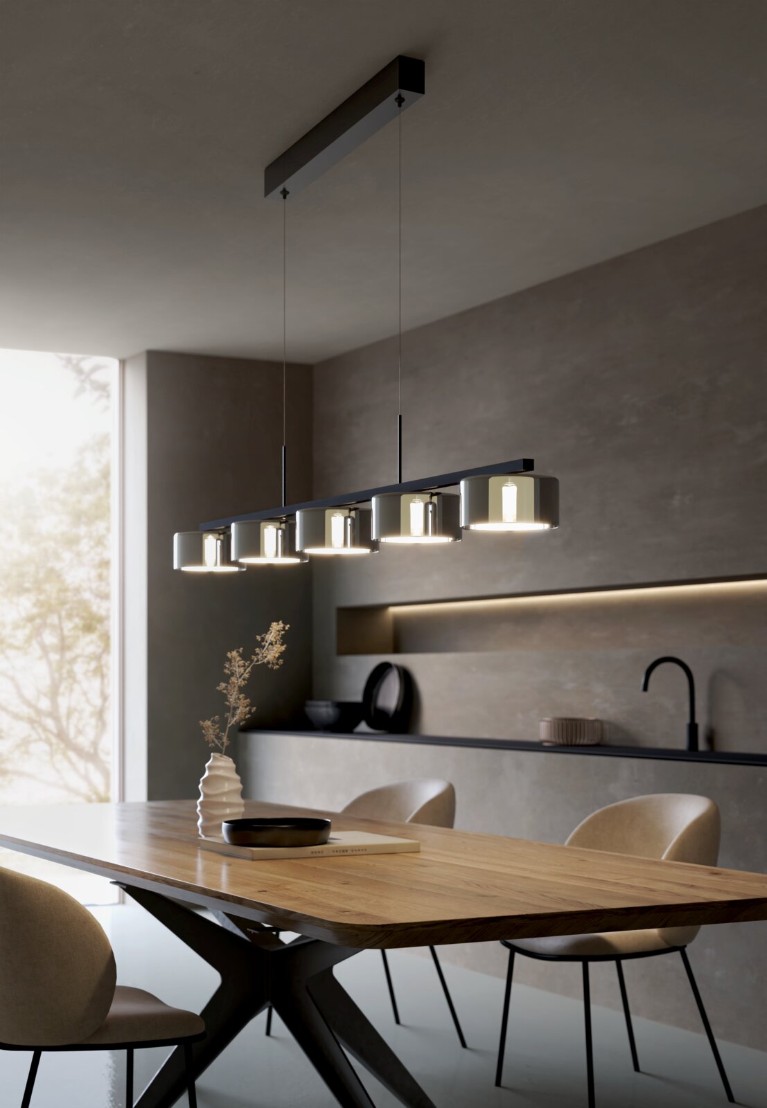 Moderne lineare Pendelleuchte mit sechs zylindrischen Glasschirmen in Schwarz über einem Esstisch in einer minimalistischen Küche, perspektivische Seitenansicht leicht von unten