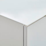 Nahaufnahme einer Ecke eines Highboards mit weißer, glänzender Oberfläche und klaren Linien.