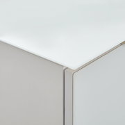 Nahaufnahme einer Ecke eines Highboards mit weißer, glänzender Oberfläche und klaren Linien.