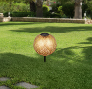 Solarleuchte mit dekorativem Muster auf einer grünen Rasenfläche, seitliche Perspektive