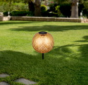 Solarleuchte mit dekorativem Muster auf einer grünen Rasenfläche, seitliche Perspektive