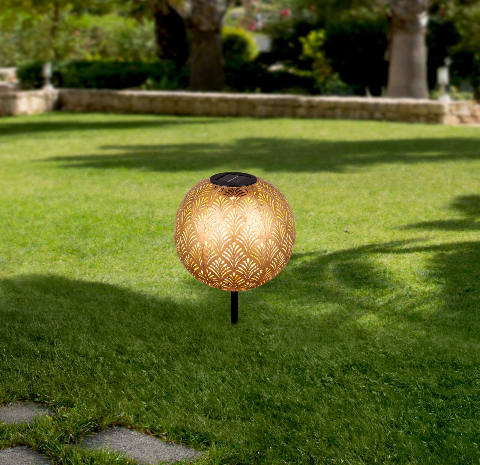 Solarleuchte mit dekorativem Muster auf einer grünen Rasenfläche, seitliche Perspektive