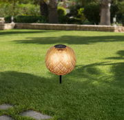 Solarleuchte mit dekorativem Muster auf einer grünen Rasenfläche, seitliche Perspektive