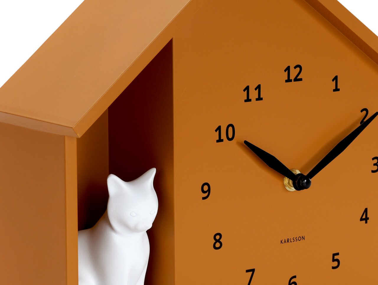Nahaufnahme einer orangefarbenen Wanduhr mit schwarzem Zifferblatt und Zeigern, sowie einer weißen Katzenfigur in einem seitlichen Fach.
