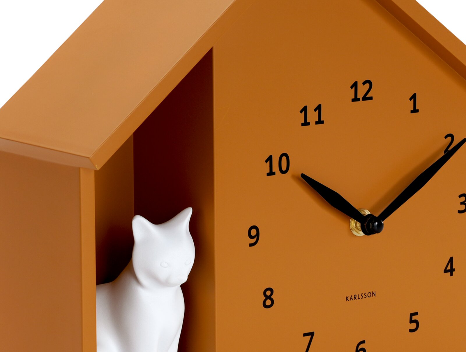 Close-up van een oranje wandklok met een zwarte wijzerplaat en wijzers, en een wit kattenbeeldje in een vakje aan de zijkant.