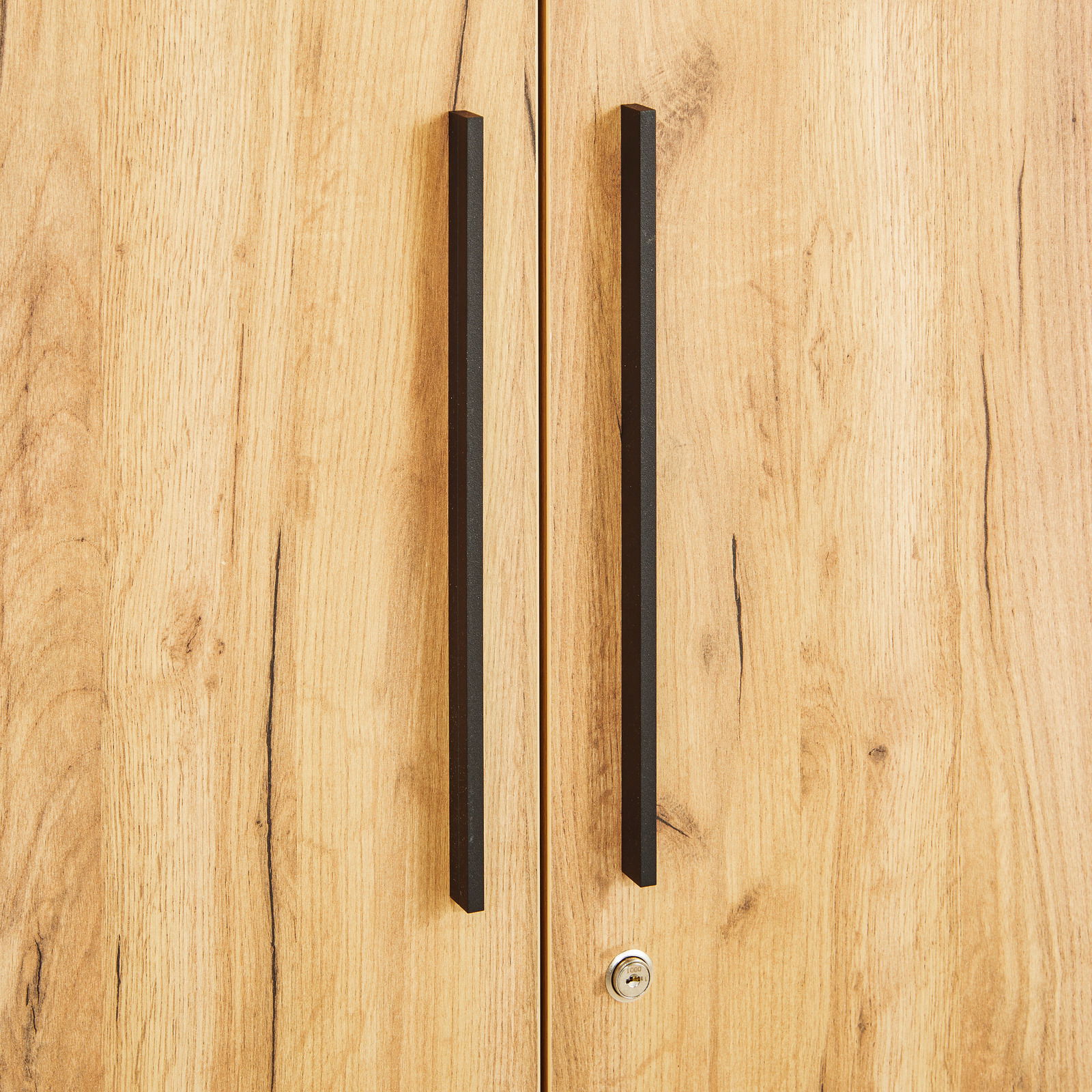Nahaufnahme eines Aktenschranks mit Holzoptik und schwarzen Griffen, frontale Perspektive