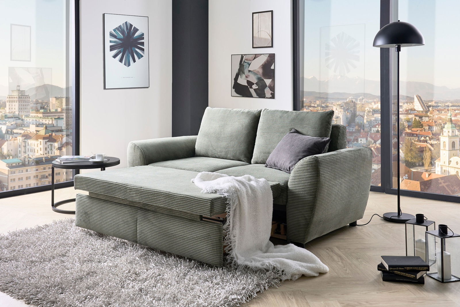 Funktionssofa in einem modernen Wohnzimmer mit Panoramablick, von vorne betrachtet.