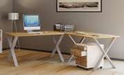 Moderner L-förmiger Schreibtisch aus hellem Holz mit weißen X-Gestellen und Rollcontainer mit Holzfronten im Homeoffice, seitliche Perspektive schräg von vorne.