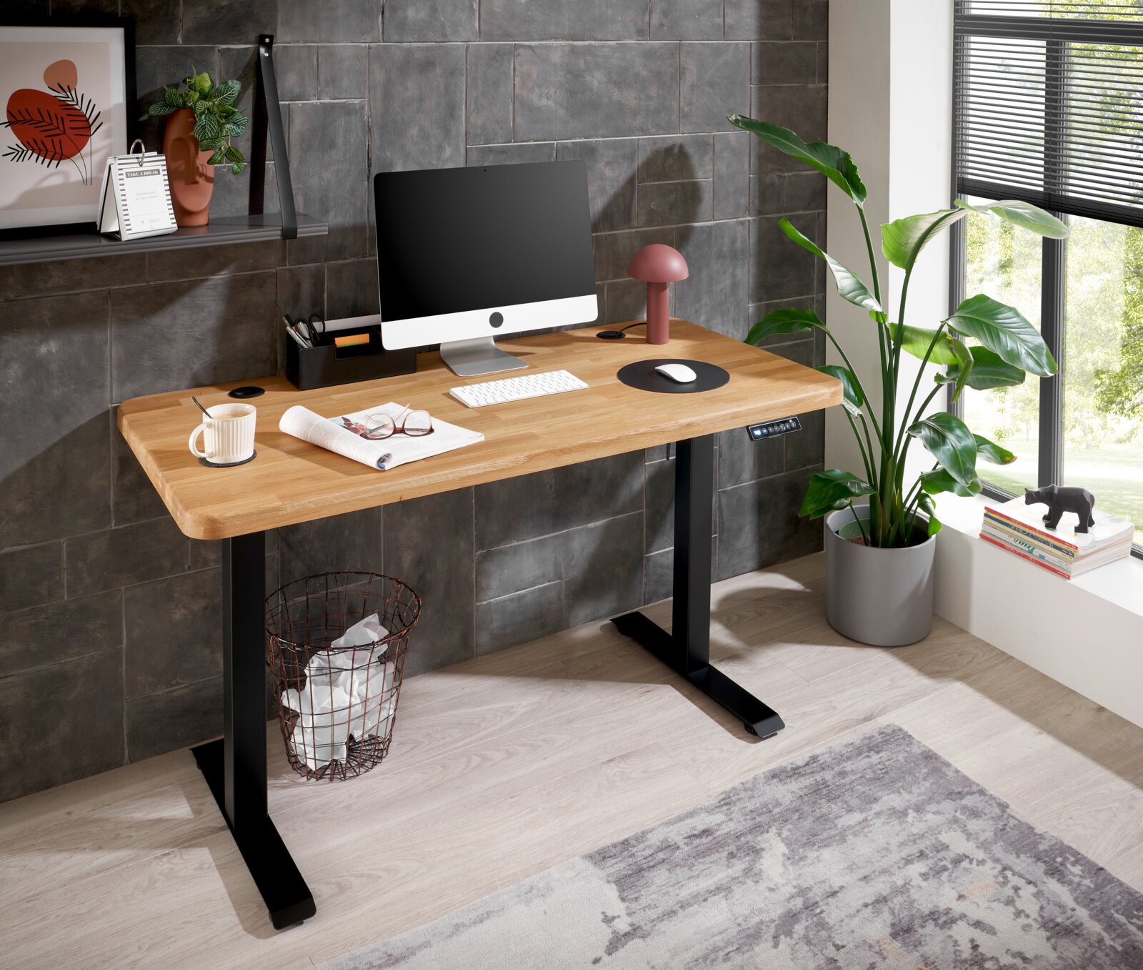 Moderner E-Schreibtisch mit Holzplatte und schwarzem Gestell, seitliche Perspektive, ausgestattet mit Computer, Lampe und Pflanzen.