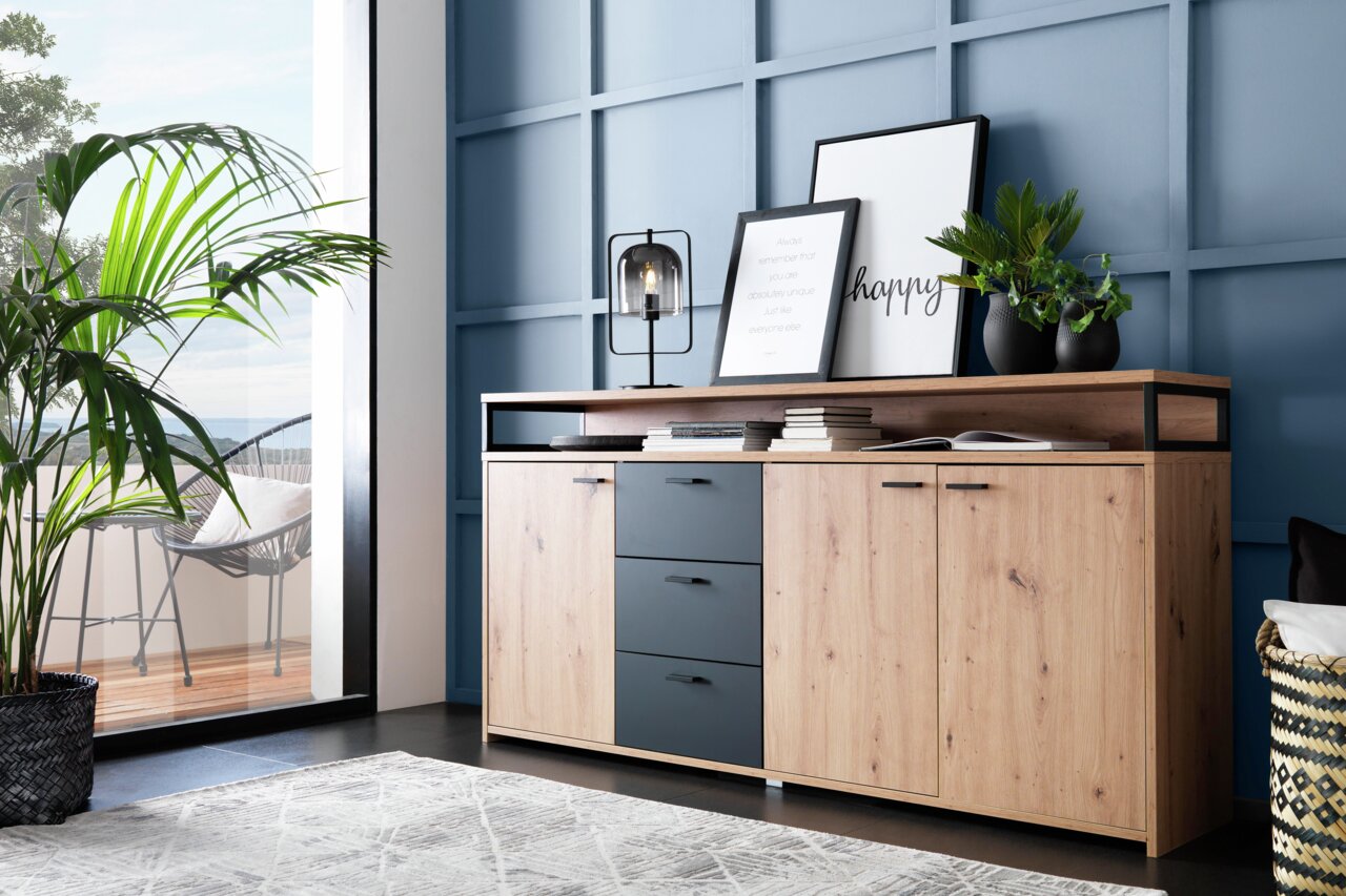 XL-Sideboard aus Holz mit drei Schubladen und zwei Türen, dekoriert mit Pflanzen und Bildern, seitliche Perspektive