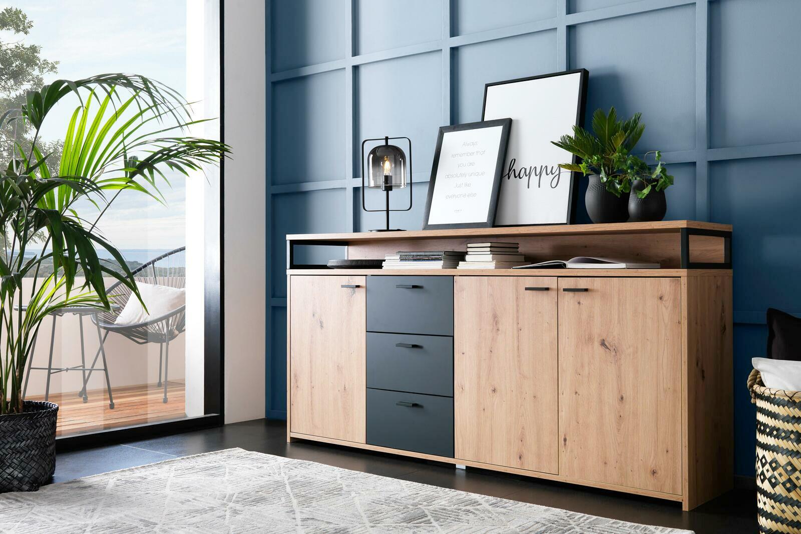 XL-Sideboard aus Holz mit drei Schubladen und zwei Türen, dekoriert mit Pflanzen und Bildern, seitliche Perspektive