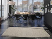 Handgewebter Teppich in einem modernen Esszimmer mit Blick auf große Fenster und einen Esstisch mit schwarzen Stühlen.