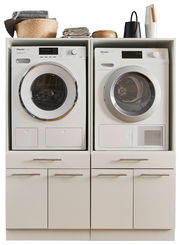 Frontansicht einer Hauswirtschaftsraum-Kombination mit Waschmaschine und Trockner, umgeben von Schränken und Ablageflächen.