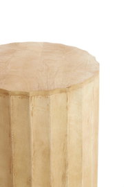 Nahaufnahme eines hellen, naturfarbenen Holz-Hockers/Beistelltischs mit facettierter, polygonaler Form; Perspektive schräg von oben auf die Oberkante und Seitenfläche vor weißem Hintergrund.