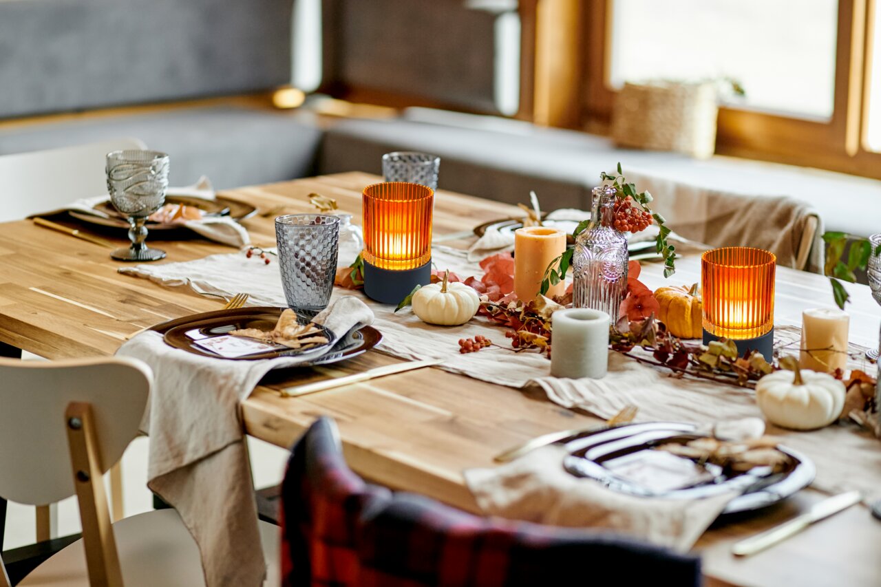 Stimmungsvolle Tischdekoration mit Akku-Windlicht in herbstlicher Atmosphäre, seitliche Perspektive