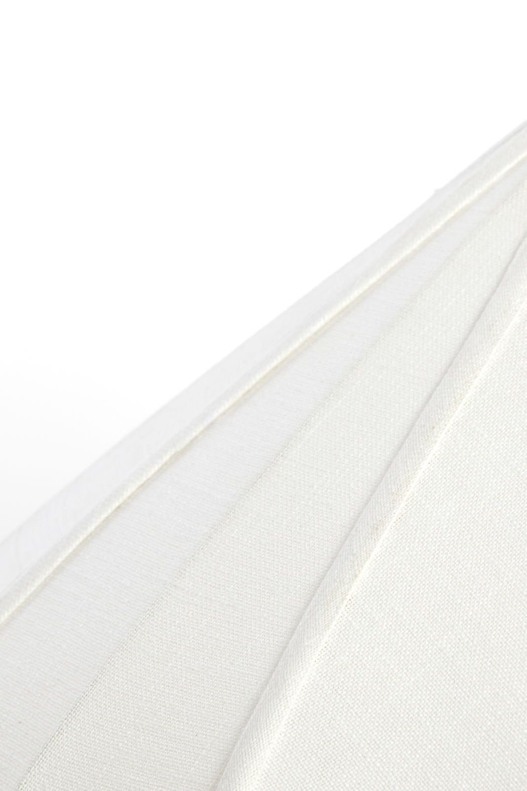 Nahaufnahme einer weißen Hängeleuchte aus Stoff, die die Textur und die Falten des Materials zeigt.